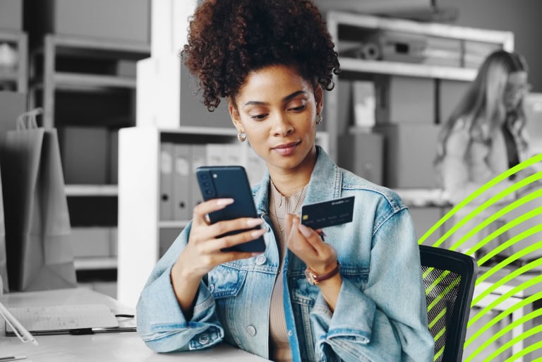 woman holding a smartphone typing in credit card details